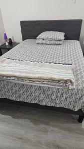 een bed met een deken en kussens erop bij Bright and Cozy Room with Free Parking in Edmonton