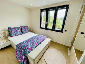 Un dormitorio pequeño con una cama y una ventana. en Stylish, Calm and Green Home Stay, en Saint-Fargeau-Ponthierry