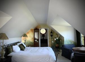 1 dormitorio con 1 cama blanca y 1 sofá azul en Le Mange Grenouille en Bic