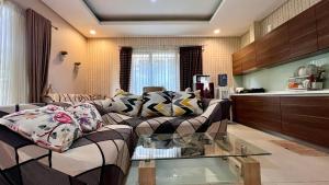 un soggiorno con divano e tavolo in vetro di Vimala Hills Villa & Resort Megamendung Puncak a Bogor