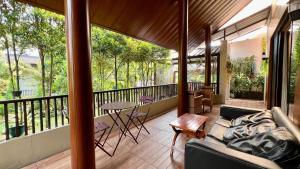een woonkamer met een bank en een tafel op een balkon bij Vimala Hills Villa & Resort Megamendung Puncak in Bogor
