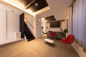 a living room with red chairs and a couch at Biei Villa Gen in Biei