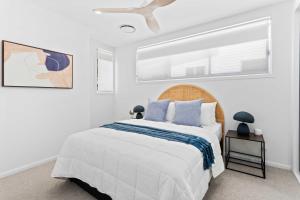 une chambre blanche avec un lit et une fenêtre dans l'établissement Haven On Hooper, à Gold Coast