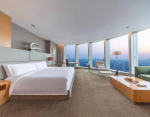 Pokój hotelowy z dużym białym łóżkiem i oknami w obiekcie InterContinental Nanjing, an IHG Hotel w mieście Nankin