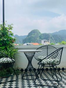a table and chairs on a balcony with mountains in the background at Della Luna Tam Cốc in Ninh Binh