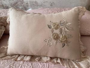 a pillow with flowers on it sitting on a bed at Appartamento Biancospino in Abbadia San Salvatore