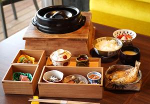 una mesa cubierta con cajas de madera llenas de diferentes tipos de comida en Toriizaki Club HOTEL and SEAFOODS en Kisarazu