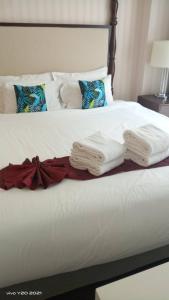 Una cama con toallas blancas encima. en Grand Florida Beach Waterpark Condo Resort, en Na Jomtien