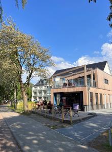 FuhlendorfにあるFerienhäuser Baltic Lagoon Haus 14cの建物前のベンチに座る人々