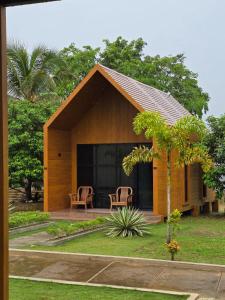 een klein huis met stoelen en een patio bij Awandari Resort & Convention in Kangkakawal