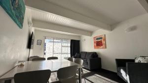een woonkamer met een tafel en stoelen bij Gables Lakefront Resort in Taupo