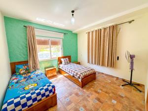 - une chambre avec 2 lits et une fenêtre dans l'établissement Luxury duplex with private pool - Sea view and Fast wifi, à Oued Laou