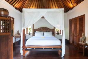 1 dormitorio con 1 cama con dosel en Villa Pangi Gita, en Canggu