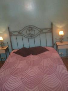 1 cama rosa grande en un dormitorio con 2 mesas en Residencia "Libertad " en San Andrés