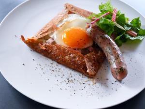 a plate of food with an egg and sausage and toast at WeBase KAMAKURA in Kamakura