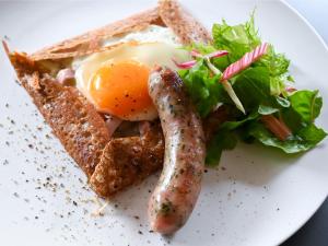 a plate with an egg and a sausage and a salad at WeBase KAMAKURA in Kamakura