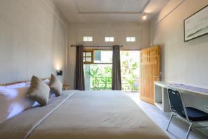 - une chambre avec un grand lit et un bureau dans l'établissement Sanava Balian, à Balian