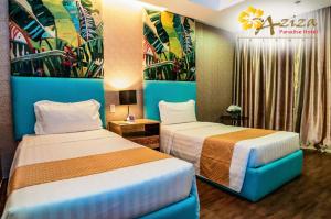 una camera d'albergo con due letti e un cartello di Aziza Paradise Hotel a Città di Puerto Princesa