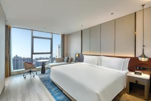 ein großes weißes Bett in einem Zimmer mit einem großen Fenster in der Unterkunft Crowne Plaza Xi'an Weiyang, an IHG Hotel in Xi'an