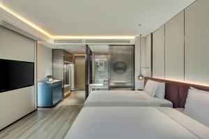 um quarto de hotel com duas camas e uma televisão em Crowne Plaza Xi'an Weiyang, an IHG Hotel em Xian