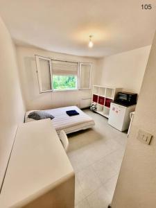 a small room with a bed and a kitchen at Studio 105 - Calme & Tout Equipé avec Parking Gratuit in Grenoble