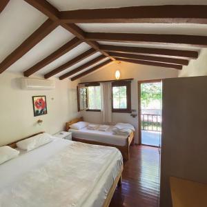 a bedroom with two beds and a window at Montenegro Motel in Faralya