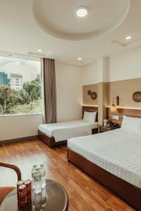 una camera d'albergo con due letti e un tavolo di Lantern Hotel ad Ho Chi Minh