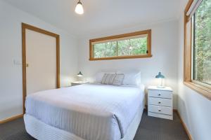 sypialnia z białym łóżkiem i oknem w obiekcie Freycinet Sanctuary 4 w mieście Coles Bay