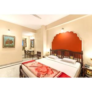 a bedroom with a large bed with a red headboard at WelcomHeritage Kalyan Bhawan Hotel in Jaisalmer