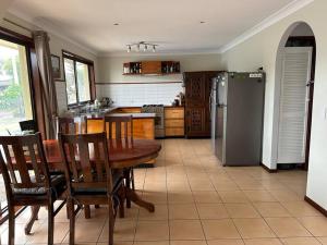 a kitchen with a table and a refrigerator at House and Van on the River in Tweed Heads