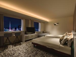 東京にあるロッテシティホテル錦糸町のベッド、デスク、テレビが備わるホテルルームです。