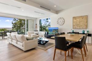 a living room with a table and chairs at The Rise Noosa in Noosa Heads
