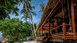 a building on the beach with palm trees at Ten Moons Lipe Resort in Ko Lipe