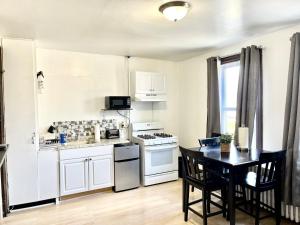 a kitchen with a table and a stove top oven at 3 Bedrooms, Boardwalk Duplex Beachblock Home! in Atlantic City