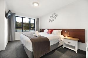 a bedroom with a large bed and a window at Town centre house. Perfect for families and groups in Queenstown