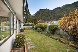 a yard next to a house with a window at Town centre house. Perfect for families and groups in Queenstown