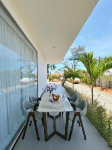 a dining room with a table and chairs on a balcony at TP-HOMES PHAN THIẾT in Phan Thiet