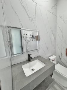 ein weißes Bad mit einem Waschbecken und einem WC in der Unterkunft TP-HOMES PHAN THIẾT in Phan Thiet