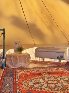 Zimmer mit einem Zelt mit einem Teppich und einem Tisch in der Unterkunft TP-HOMES PHAN THIẾT in Phan Thiet