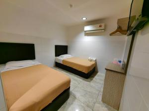Habitación de hotel con 2 camas y TV en Comfort Two Hotel, en Melaka