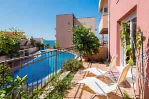 a balcony with two chairs and a swimming pool at Laura Apartment in Trogir