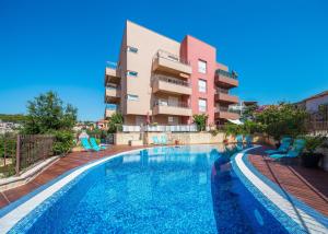 una piscina di fronte a un condominio di Laura Apartment a Trogir