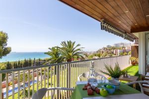 a table on a balcony with a view of the ocean at Verd i Blau - Apartament amb Piscina in Tarragona