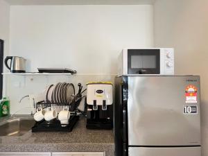 a kitchen with a microwave on top of a refrigerator at RiverView 8PAX 3BR in KBtown Wi-Fi, B-12-3 in Kota Bharu