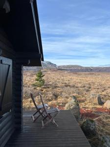 a pair of chairs sitting on the porch of a house at Cosy cabin with amazing view on the Geysir in Blaskogabyggd
