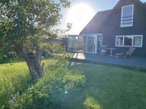 una casa con un cortile con un albero e una terrazza di Charming Townhouse With Plenty Of Space a Thyborøn