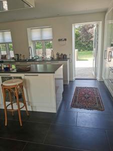 a kitchen with a counter and a table and a stool at Lovely Farmhouse For The Whole Family in Slagelse