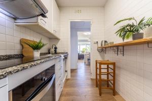 a kitchen with white tile walls and a counter at Verd i Blau - Apartament amb Piscina in Tarragona