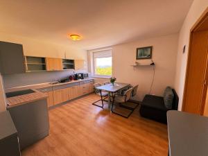 a kitchen with a table and a dining room at Apartmány Slavkov - Dolný Smokovec in Vysoke Tatry - Dolny Smokovec