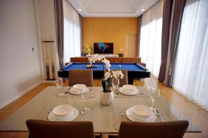 a dining room with a table with chairs and a pool table at Nattarin Pool Villa Pattaya-Na Chom Thian in Ban Map Fakthong +14 photos